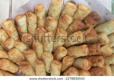 Indonesian food called fried spring rolls in woven bamboo called tampah covered with oil paper on the table