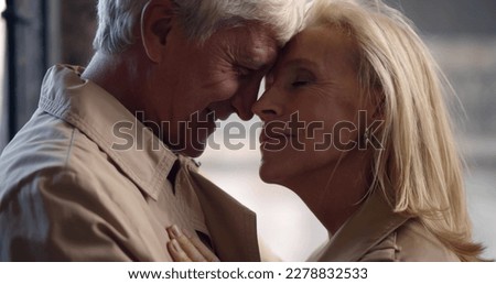 Close up of romantic aged couple cuddling and embracing outdoors. Side view of stylish mature man and woman in love hugging in city Royalty-Free Stock Photo #2278832533