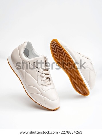 A mockup of urban style female white footwear. The shoes are positioned levitating with the white background, which makes a creative abstract display with the concept of modern fashion and comfort. Royalty-Free Stock Photo #2278834263