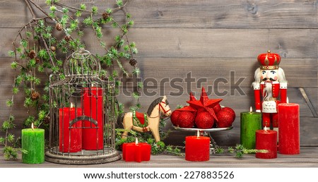 christmas decorations with red candles, vintage toys nutcracker and rocking horse. retro style toned picture