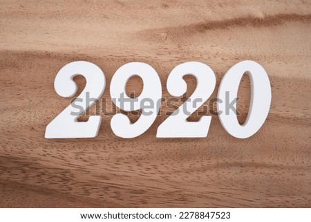 White number 2920 on a brown and light brown wooden background.