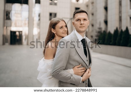 Portrait of a newly married couple. Bride standing smiling, hugging groom. Concept of love and happiness. Royalty-Free Stock Photo #2278848991