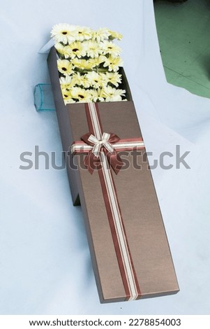 A bunch of flowers in a beautiful gift box, Barberton. daisy,rose multi-colored