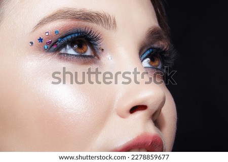 Closeup shot of human woman face. Female with natural face and eyes beauty makeup with blue eye shadow make up and rhinestones. Royalty-Free Stock Photo #2278859677