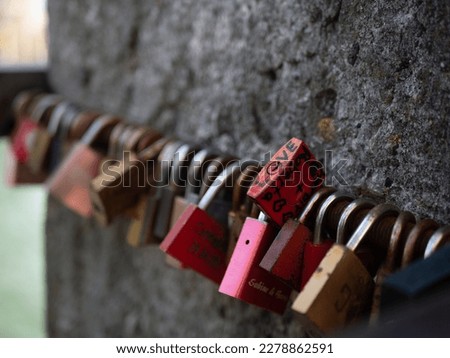 This romantic photo captures a colorful array of love locks attached to a bridge, symbolizing everlasting love and commitment. Perfect for Valentine's Day and romance-themed designs.