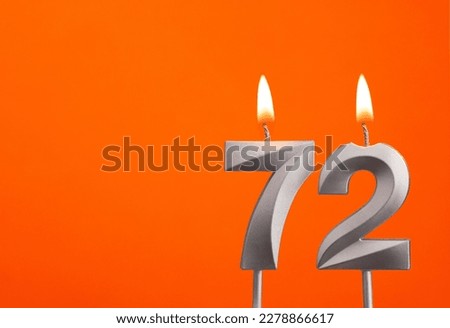 Candle number 72 - Birthday in orange background Royalty-Free Stock Photo #2278866617