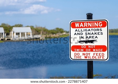 Sign warning about snakes and alligators in a Florida lake