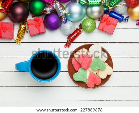 Cup of coffee and cookie with christmas toys on white background.