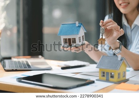Cropped shot of a real estate agent or banker handing over a key to their customer after signing a contract