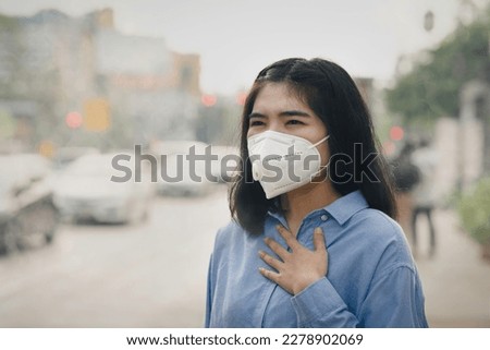 Asian woman wearing the N95 Respiratory Protection Mask against PM2.5 air pollution and headache Suffocate. City air pollution concept Royalty-Free Stock Photo #2278902069