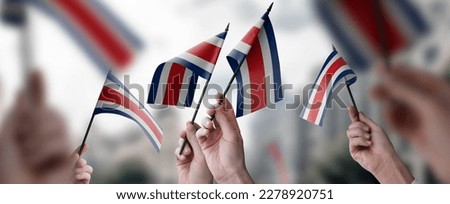 A group of people holding small flags of the Costa Rica in their hands. Royalty-Free Stock Photo #2278920751