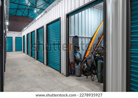 Outdoors activity items seen through the open door of the self storage unit. Rental Storage Units Royalty-Free Stock Photo #2278935927