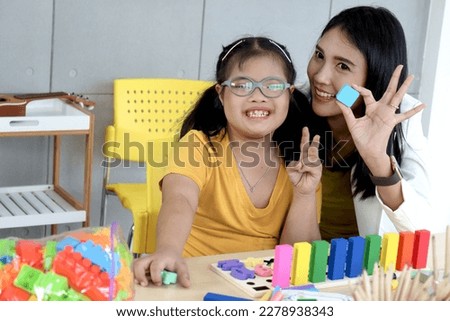 Happy children have fun study at school, disabled kids classroom, smiling girl with down syndrome learn and play with teacher in classroom, education of kids with physical disability and intellectual.