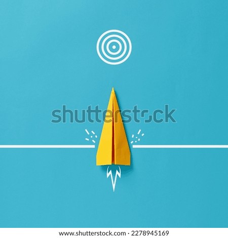 Conquering adversity to achieve goals. Determination to reach for business objectives. To overcome barriers and difficulties. Paper airplane crashes a wall and moves towards the target goal symbol. Royalty-Free Stock Photo #2278945169