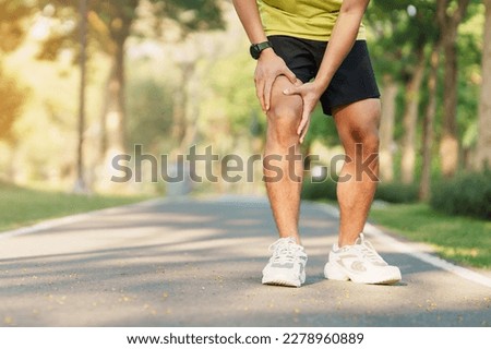 Young adult male with muscle pain during running. runner have knee ache due to Runners Knee or Patellofemoral Pain Syndrome, osteoarthritis and Patellar Tendinitis. Sports injuries and medical concept Royalty-Free Stock Photo #2278960889