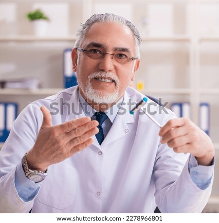 Aged male doctor with hammer