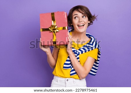 Photo of cheerful adorable cute lady wear stylish striped clothes hold receive giftbox empty space isolated on purple color background
