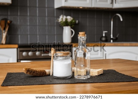 Using baking soda Sodium bicarbonate and white vinegar for home kitchen cleaning concept. White vinegar in glass bottle and baking soda in glass jar. Royalty-Free Stock Photo #2278976671