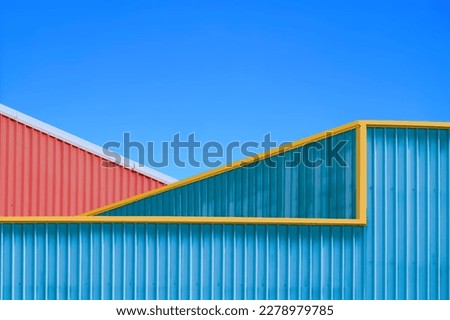 Two Colorful Corrugated Steel Warehouse Industrial Buildings against blue clear sky in Minimal style, Exterior Architecture Background Design concept Royalty-Free Stock Photo #2278979785