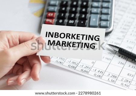 Inborketing marketing text on a card in the hands of a businessman on the background of an office desk, a business concept