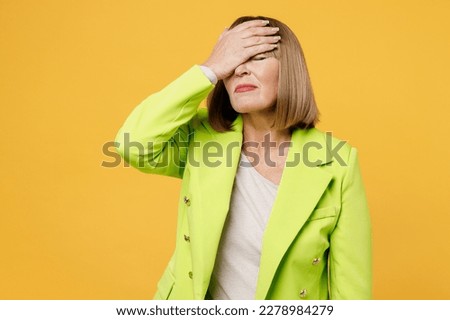 Elderly bored woman 50s years old wear green jacket white t-shirt put hand on face facepalm epic fail mistaken omg gesture isolated on plain yellow background studio portrait. People lifestyle concept Royalty-Free Stock Photo #2278984279