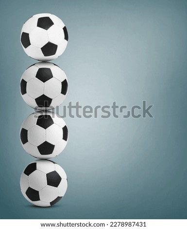 Stack of soccer balls on dusty light blue background. Space for text