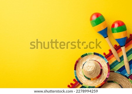 Cinco-de-mayo carnival concept. Top view photo of sombrero colorful striped poncho and couple of maracas on isolated vibrant yellow background with blank space Royalty-Free Stock Photo #2278994259