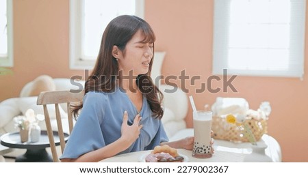 asian woman eat high sugar content food and has Gastroesophageal Reflux Disease feel regret Royalty-Free Stock Photo #2279002367