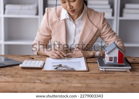 Business woman Real estate broker agent working with home model document presenting and sign insurance form agreement consult concerning mortgage loan offer in office.