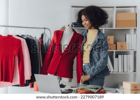 Happy smiling Asian creative fashion designer is working owner working in her tailor shop. Woman creating new clothes collection concept.
