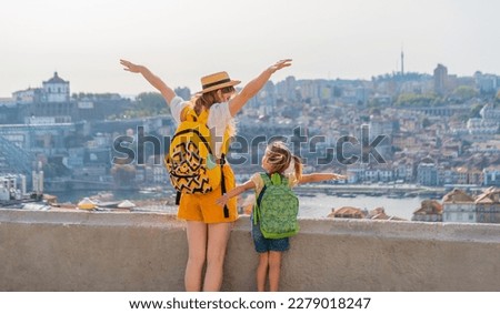 View from behind of Young red-haired mother and little daughter raised thair hands up against the Porto city, Portugal Royalty-Free Stock Photo #2279018247