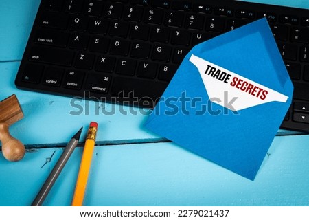 TRADE SECRETS Concept. Letter and computer keyboard on blue office desk.