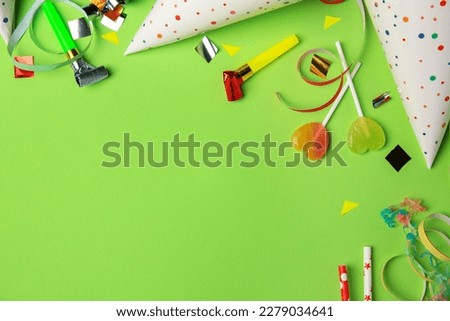 Colorful blowers, streamers and other festive decor on light green background, flat lay. Space for text