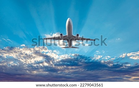 White passenger airplane flying in the sky amazing clouds in the background - Travel by air transport Royalty-Free Stock Photo #2279043561