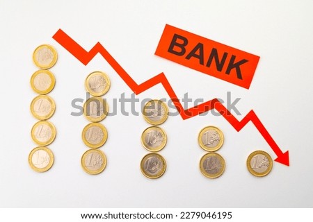 Rows of coins of descending height, descending red line, and the word Bank. Failure of banks and collapse of stock exchanges and yields.
 Royalty-Free Stock Photo #2279046195