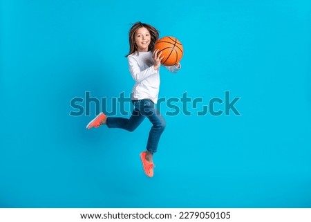 Full size photo of optimistic active girl wear white long sleeve trousers running with basketball ball isolated on blue color background Royalty-Free Stock Photo #2279050105