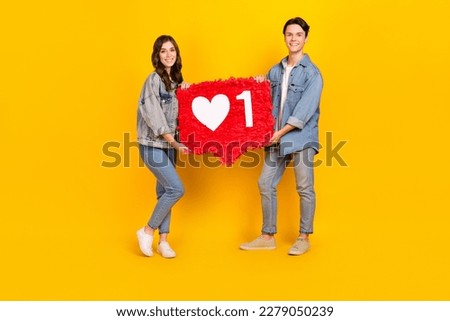 Full length photo of charming cute best buddies wear jeans rising heart feedback pinata isolated yellow color background
