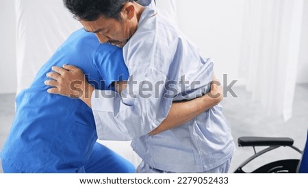 A caregiver transferring an elderly person from a nursing bed to a wheelchair. Royalty-Free Stock Photo #2279052433