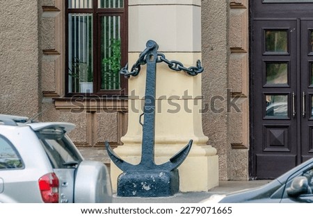 Large metal black anchor at the entrance to the building