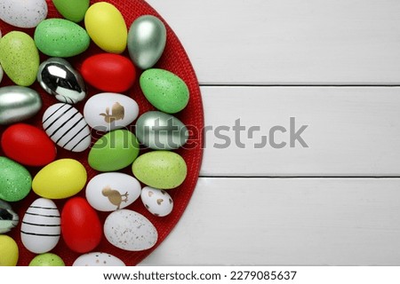 Many beautifully decorated Easter eggs on white wooden table, top view. Space for text