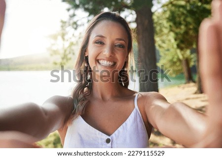 Nature, happy and woman taking a selfie in the forest while on outdoor adventure alone on a weekend trip. Happiness, smile and portrait of female taking picture in woods on travel holiday or vacation