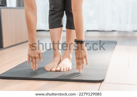 Picture of a beautiful girl practicing indoor yoga, calm and relaxed, preparation a yoga mat for her exercise.