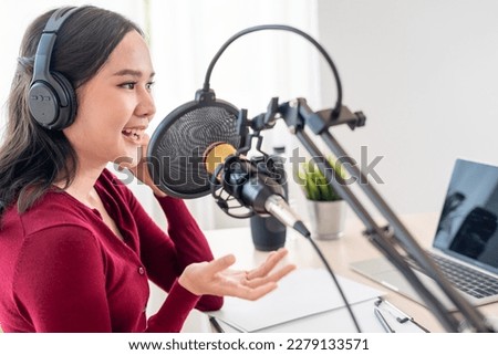 Asian woman is speaking to encourage on a radio broadcasting station. beautiful female organized the radio program. Radio, podcast, live steaming, entertainment, listen, technology, music, speaker