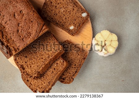 whole grain garlic bread on wooden board, banner, menu, recipe place for text, top view,