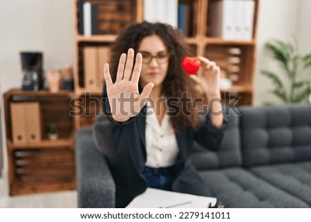 Young hispanic woman working on couple therapy at consultation office with open hand doing stop sign with serious and confident expression, defense gesture 