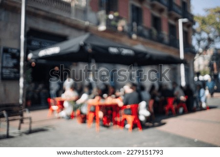 Blurred abstract background of outdoor cafe or restaurant. Outdoor cafe with tables and chairs. Street cafe in the afternoon in Valencia Spain . Customers sit at tables in a terrace area outside cafe