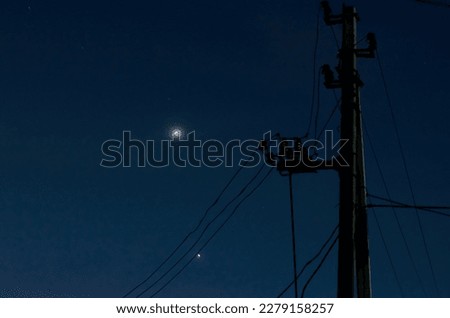 the night sky with the glowing planets Venus and Jupiter, and an electric pole