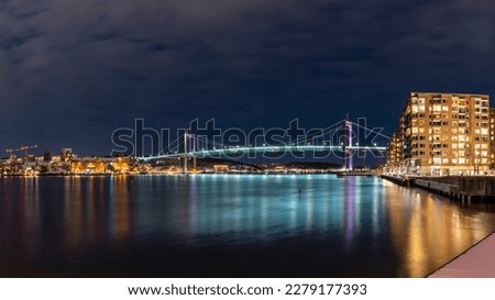  Gothenburg Midnight Skyline with Outlook over illuminated Alvsborgs Bridge reflecting in water of Gota Alv River in Sweden.  Royalty-Free Stock Photo #2279177393