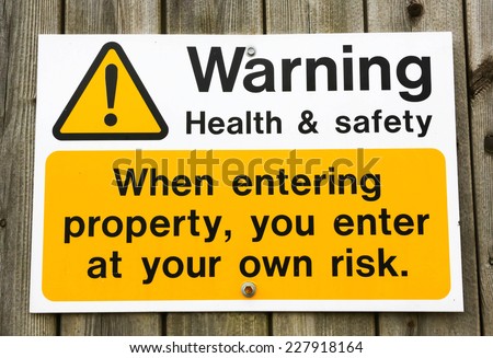 Health and Safety warning sign advising that you enter a building at your own risk.
