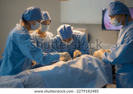 Doctor, nurse doing surgery on patient in operating room.